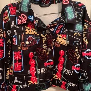 This is a black jean jacket with colorful graphic detail.